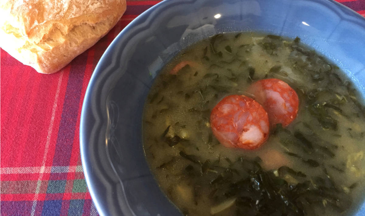 Caldo Verde com chouriço servido em prato de gré