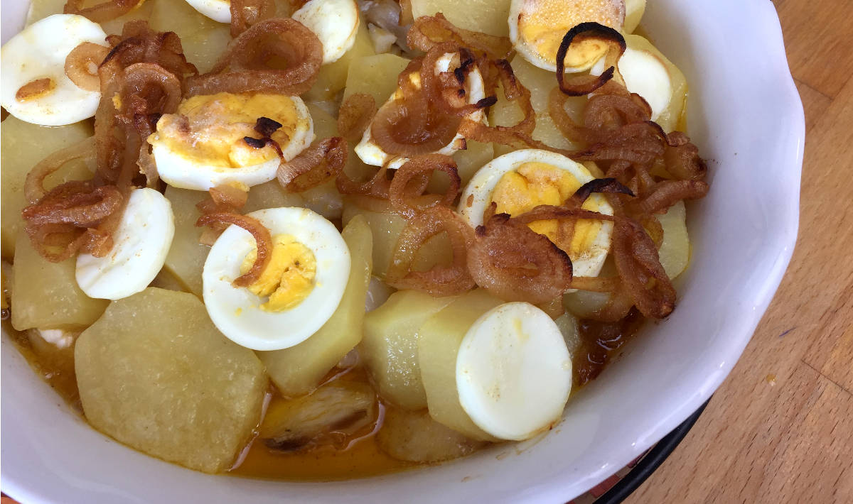 Bacalhau à Gomes de Sá Especial com escabeche servido numa travessa redonda